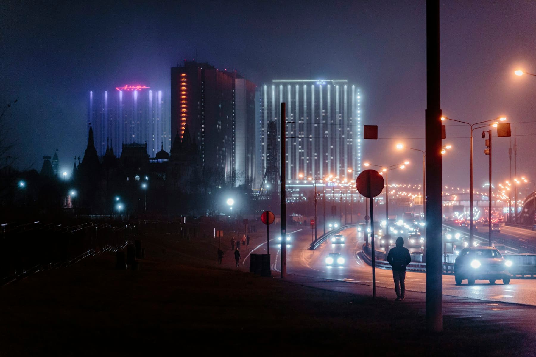 City skyline at night with glowing buildings and traffic