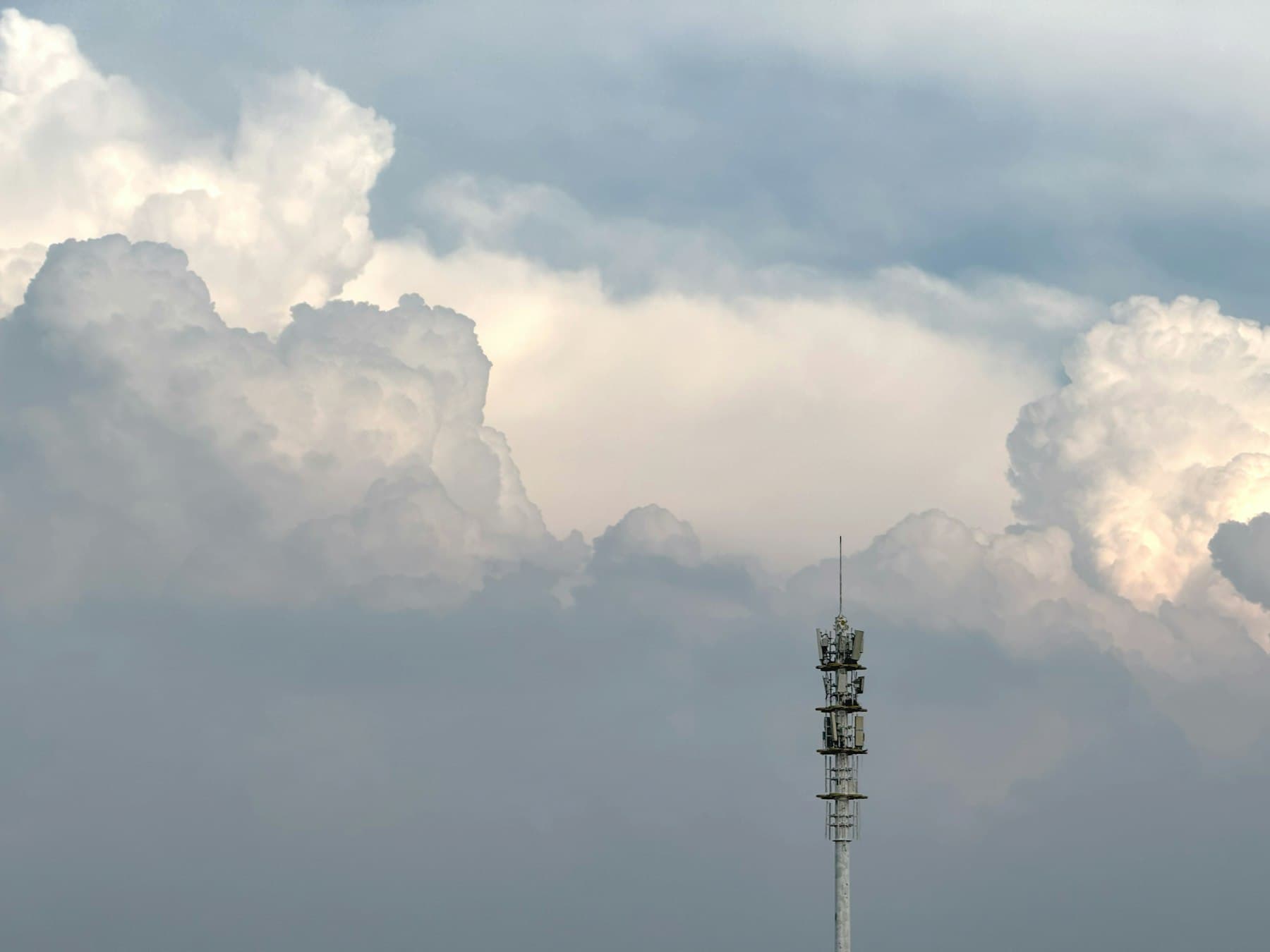 Communication tower against a dramatic cloudy sky