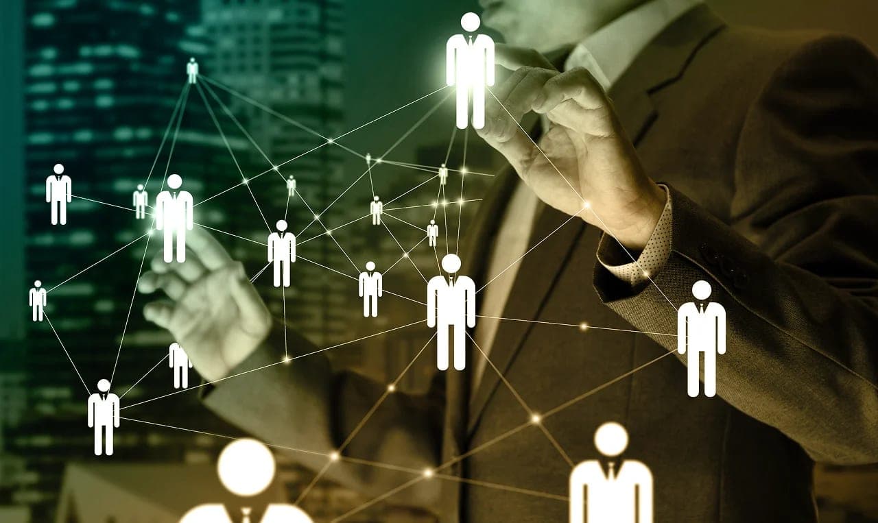 A professional gesturing toward a connected network of people icons against a city skyline.
