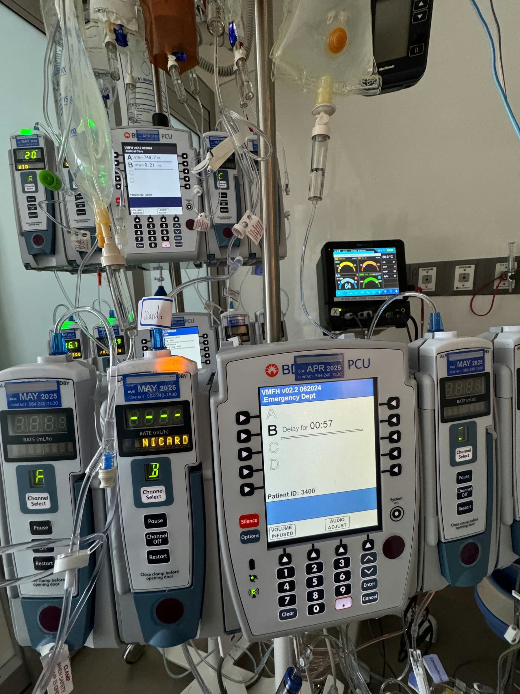 Rows of infusion pumps and monitoring equipment at a hospital bedside