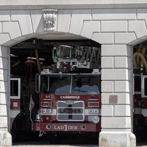 Fire engine standing in the arched apparatus bay of a city fire station